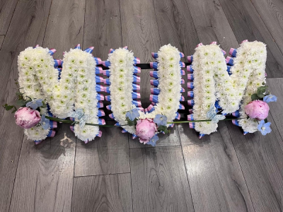 Mum Lavender Letter Tribute - A beautifully handcrafted MUM funeral letter tribute, created with fresh white chrysanthemums and finished with coordinating ribbon and delicate floral sprays.