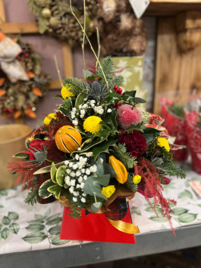 Winter Spice - A charming Christmas arrangement combining rich reds, cheerful yellows and seasonal greenery, finished with festive touches. Handcrafted by Daisy Chain Florist in Scunthorpe.