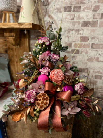 Rose Gold Christmas - A luxurious festive arrangement of pink roses, orchids and seasonal foliage, finished with rose gold accents and ribbon. Handcrafted by Daisy Chain Florist in Scunthorpe.