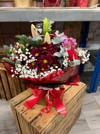 Festive Berry Bliss - A beautiful festive arrangement featuring rich burgundy blooms, pink daisies, lilies and seasonal foliage. Handcrafted by Daisy Chain Florist in Scunthorpe.