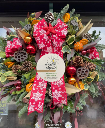 Christmas Wreath - A festive wreath featuring lush evergreen foliage, pine cones, dried oranges and Christmas baubles. Handcrafted by Daisy Chain Florist in Scunthorpe.